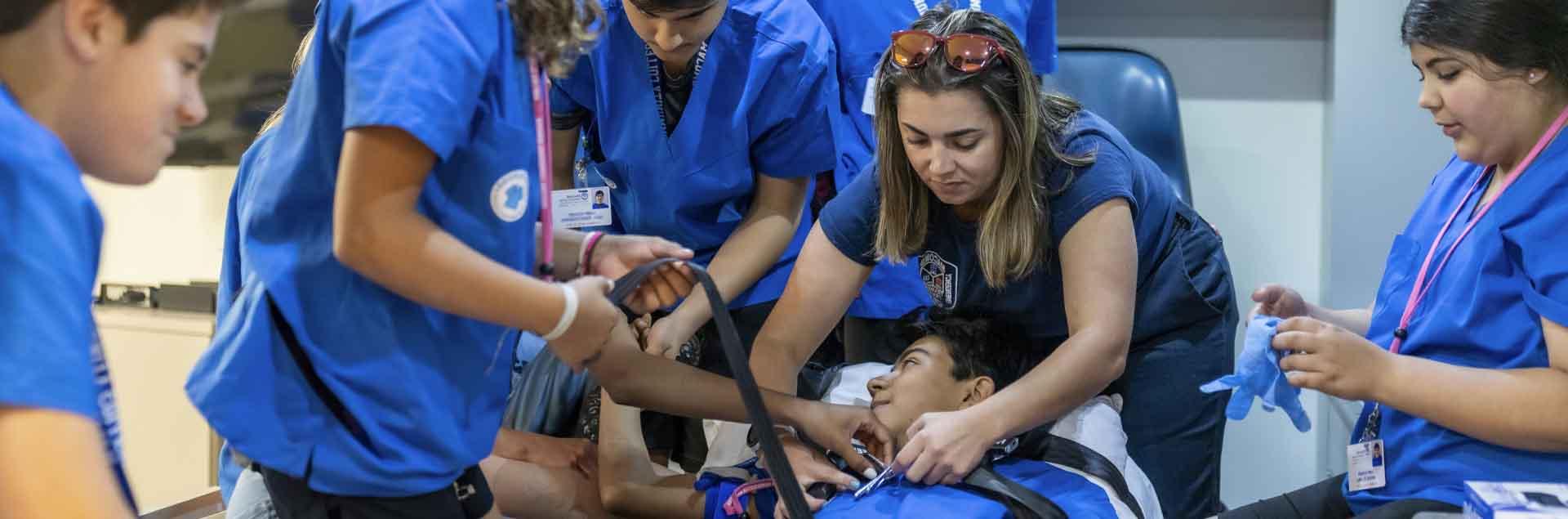 来自2023年实习医生训练营的学生们在救护车后面练习他们所学到的东西.